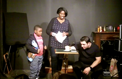 Mike Paldino performs an impossible card trick with a boy and his mom at his show in Philadelphia.
